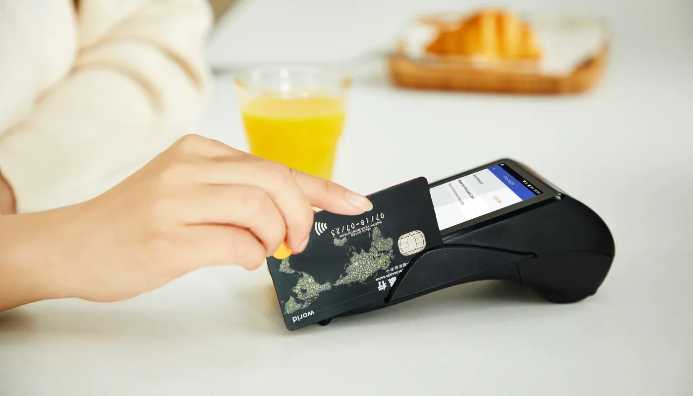 Persona usando una tarjeta de crédito en un terminal.