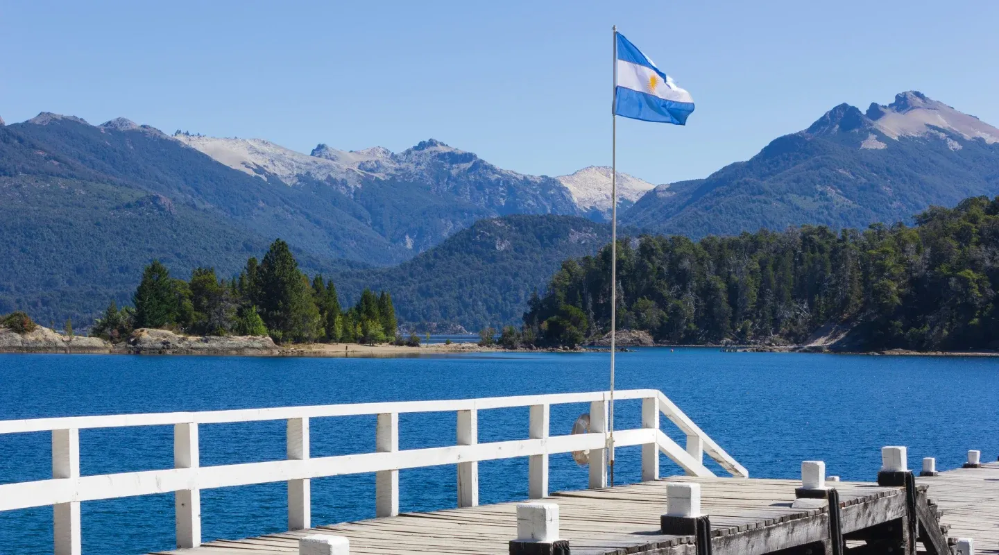 Bandera de Argentina ondeando sobre un muelle.